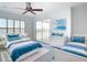 This staged bedroom offers two twin beds with blue and white bedding and a sliding door at 4440 Tatum St, Port Charlotte, FL 33948