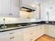 Modern kitchen with white cabinets, granite countertops, and stainless steel appliances at 4440 Tatum St, Port Charlotte, FL 33948