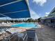 Large community pool with plenty of lounge chairs for sunbathing at 6713 Stone River Rd # 205, Bradenton, FL 34203