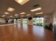 Bright exercise room with wood floors, mirrors, and windows overlooking a tranquil pond at 6713 Stone River Rd # 205, Bradenton, FL 34203