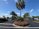 Attractive community entrance with lush landscaping and palm trees at 6713 Stone River Rd # 205, Bradenton, FL 34203