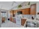Kitchen with wood cabinets, white appliances, and floral wallpaper at 6713 Stone River Rd # 205, Bradenton, FL 34203