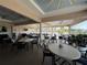 Covered lanai with tables, chairs, and screens at 6713 Stone River Rd # 205, Bradenton, FL 34203