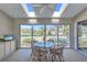 Bright sunroom with glass sliders, seating for four, and golf course view at 6713 Stone River Rd # 205, Bradenton, FL 34203