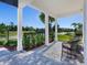 Spacious front porch with seating, white columns, and landscaping at 741 Tailwind Pl, Sarasota, FL 34240