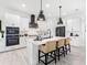 Modern white kitchen with black appliances, island with seating, and pendant lights at 741 Tailwind Pl, Sarasota, FL 34240