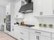 White kitchen with black accents, double oven, gas cooktop, and white tile backsplash at 741 Tailwind Pl, Sarasota, FL 34240