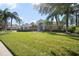 Two-story house exterior with a manicured lawn, palm trees, and a welcoming entryway at 9075 Misty Creek Dr, Sarasota, FL 34241