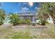Backyard of home featuring a screened-in porch, blue skies, and mature landscaping at 109 Tortuga Dr, Nokomis, FL 34275