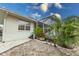 Exterior back view of home with a screened-in porch, rock garden, and lush greenery at 109 Tortuga Dr, Nokomis, FL 34275