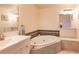 Bathroom featuring a jetted tub, tiled surround, and large vanity at 109 Tortuga Dr, Nokomis, FL 34275