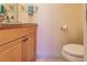 Powder room featuring a commode, and cabinet with a light stone countertop at 109 Tortuga Dr, Nokomis, FL 34275