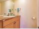 Bright half bath with light wood cabinet and stone-look countertop at 109 Tortuga Dr, Nokomis, FL 34275