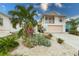 Charming two-story home featuring a balcony and lush tropical landscaping at 109 Tortuga Dr, Nokomis, FL 34275