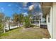 Exterior side view featuring a private dock, canal, screened-in porch, and tropical landscaping at 109 Tortuga Dr, Nokomis, FL 34275