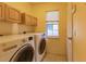 Laundry room with washer, dryer, storage cabinets and window at 109 Tortuga Dr, Nokomis, FL 34275