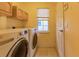 Bright laundry room with washer, dryer, cabinets, and a window at 109 Tortuga Dr, Nokomis, FL 34275