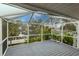 Enclosed patio with a view of the serene waterway, dock, and lush tropical landscaping at 109 Tortuga Dr, Nokomis, FL 34275