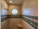 Walk-in shower featuring tiled walls, octagon window, and corner seat at 109 Tortuga Dr, Nokomis, FL 34275