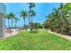 Beautiful backyard area with palm trees, a green lawn, and lounge seating at 1102 Benjamin Franklin Dr # 407, Sarasota, FL 34236