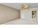 Neutral bedroom with ceiling fan and a doorway to the en-suite bathroom at 1102 Benjamin Franklin Dr # 407, Sarasota, FL 34236