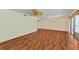 Spacious living room with wood floors, ceiling fan, and sliding doors to the balcony at 1102 Benjamin Franklin Dr # 407, Sarasota, FL 34236