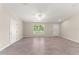 Bright living room with wood-look tile floors, neutral walls, and ample natural light at 12098 Brookside Ave, Port Charlotte, FL 33981