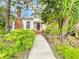 White house with brick chimney, lush landscaping, and a walkway to the front door at 1420 22Nd W St, Bradenton, FL 34205