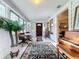 Bright and airy front porch with tiled floors, wooden furniture, and a piano at 1420 22Nd W St, Bradenton, FL 34205