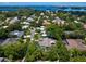 Aerial view of a waterfront home community showcasing houses, lush greenery, and a calm body of water at 1621 Pine Bay Dr, Sarasota, FL 34231