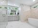 Elegant bathroom with marble walls and a soaking tub at 1621 Pine Bay Dr, Sarasota, FL 34231
