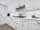 Modern kitchen with white cabinets and a geometric tile backsplash at 1621 Pine Bay Dr, Sarasota, FL 34231