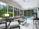 Bright sunroom with comfy seating, a large TV, and pool views at 1621 Pine Bay Dr, Sarasota, FL 34231