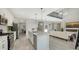 Modern kitchen with white cabinets, island, and views into the living room at 17923 Polo Trl, Bradenton, FL 34211