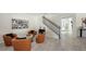A cozy living room with rod iron stairs, stylish artwork, and contemporary furniture arranged around a modern coffee table at 17923 Polo Trl, Bradenton, FL 34211