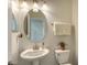 Small powder room with pedestal sink, toilet and oval mirror at 17923 Polo Trl, Bradenton, FL 34211