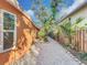 Charming side yard with gravel pathway, lush landscaping, and wooden fence at 2030 Faun Rd, Venice, FL 34293