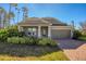 Gray house with stone accents, landscaping, and a brick driveway at 2179 W Price Blvd, North Port, FL 34286