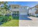 Two-story modern home featuring a gray facade, balcony, well-kept lawn, and a two-car attached garage at 2586 Prospect St, Sarasota, FL 34239