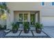Inviting front porch with modern green door, blue chairs, and decorative potted plants at 2586 Prospect St, Sarasota, FL 34239