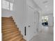 Hallway with wood stairs, white walls, closet door, and tile flooring leading to the patio at 2586 Prospect St, Sarasota, FL 34239
