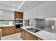 Modern kitchen featuring sleek white cabinets, stainless steel backsplash, and a built-in cooktop at 2586 Prospect St, Sarasota, FL 34239