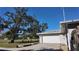 White garage door and side view of house with mature trees and landscaping at 2908 98Th E Ave, Parrish, FL 34219