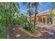Landscaped backyard with tropical plants, brick patio, and access to the home at 3614 E 62Nd Ave, Bradenton, FL 34203