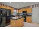 Kitchen boasts wood cabinets, black appliances, and granite countertops at 3614 E 62Nd Ave, Bradenton, FL 34203