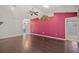 Living room with dark hardwood floors and a pink accent wall at 3614 E 62Nd Ave, Bradenton, FL 34203