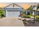 Two-car garage, light-blue exterior, landscaped front yard, and walkway at 3632 Shimmering Oaks Dr, Parrish, FL 34219