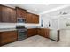 Modern kitchen with dark wood cabinets, granite countertops, and stainless steel appliances at 3632 Shimmering Oaks Dr, Parrish, FL 34219