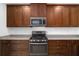 Close-up view of kitchen with dark wood cabinets and granite countertop at 3632 Shimmering Oaks Dr, Parrish, FL 34219