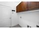 Laundry room with wooden cabinets and white walls at 3632 Shimmering Oaks Dr, Parrish, FL 34219